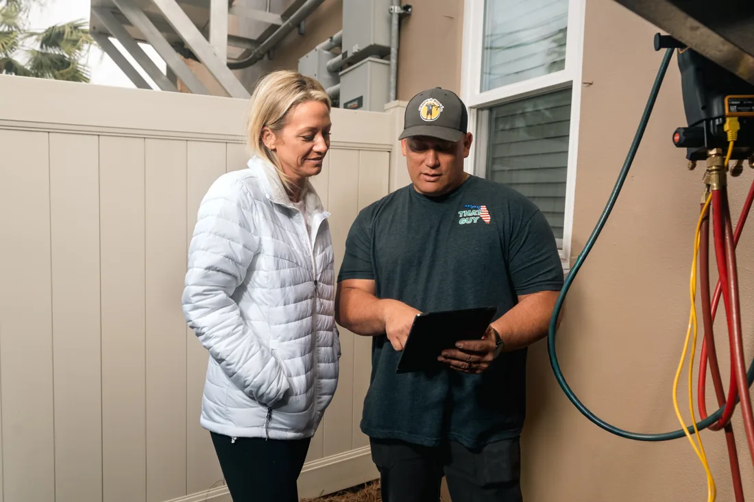 Technician showing a homeowner the estimate on a tablet