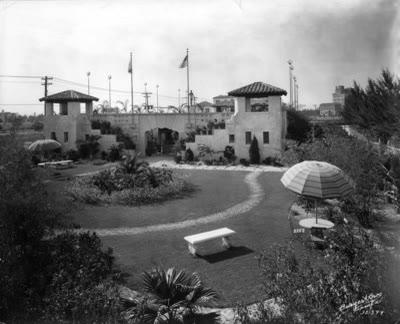 A large formal open-air swimming pool with landscaped gardens and pavilions, photographed in 1930.