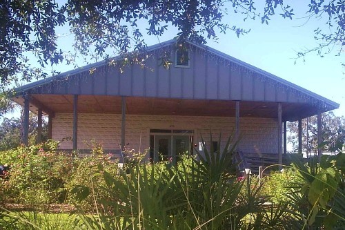 A small weathered wood-frame feed store building with a covered porch, preserved as a museum.